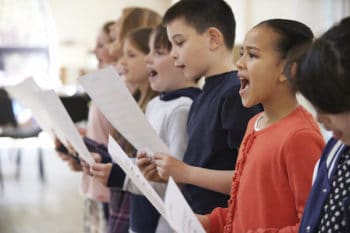 Singing Helps Kids with Cochlear Implants Group Of School Children Singing In Choir Together