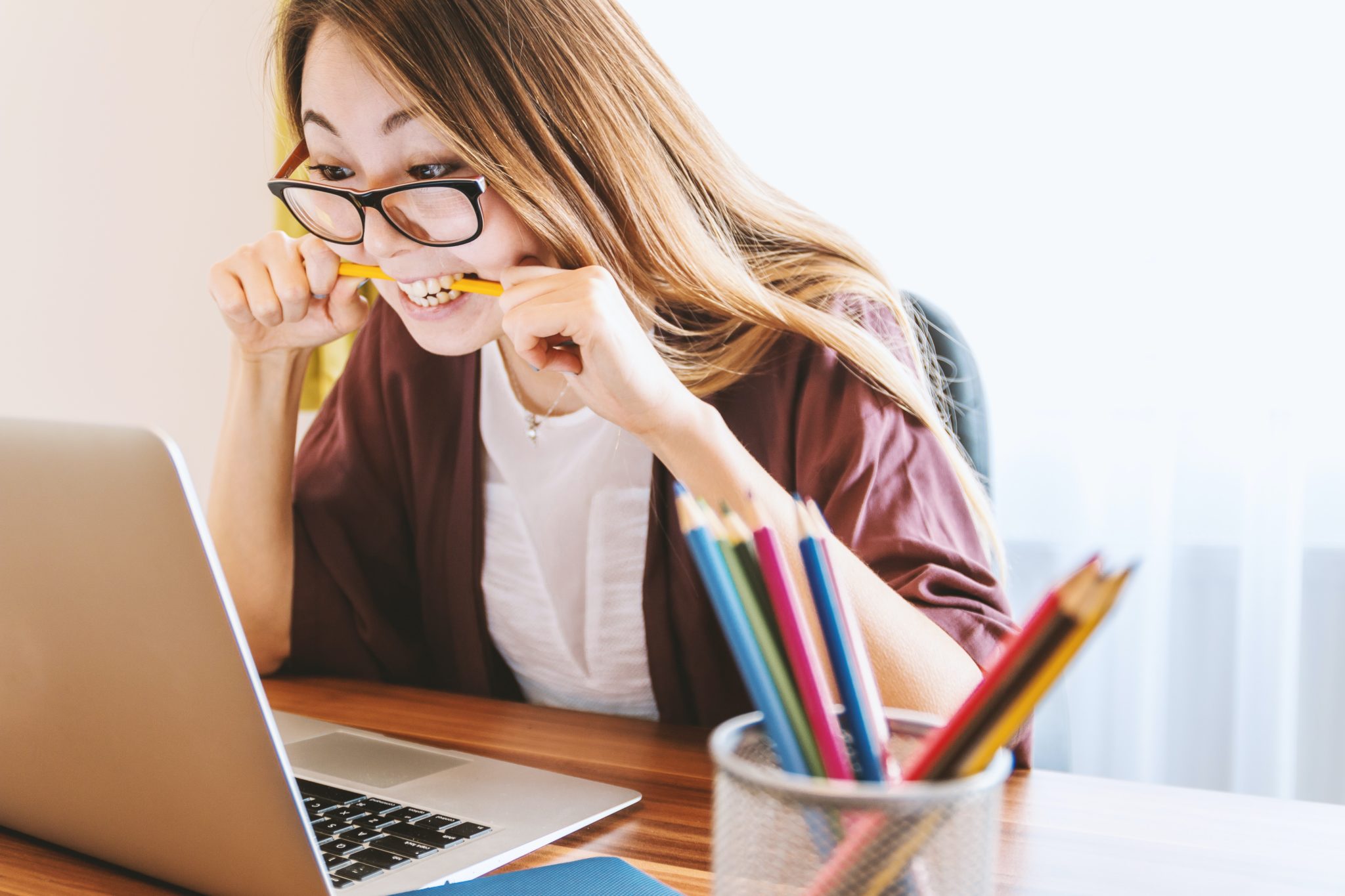 stress and tinnitus woman biting on pencil looking at computer