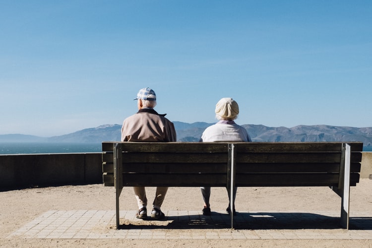 How Hearing Loss Affects Seniors Two elderly seniors sitting on a bench