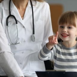 Child playing with a doctor in an office.