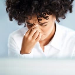 Woman experiencing sinus pressure from allergies.