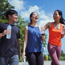 Laughing group of friends in a park wearing workout clothing.