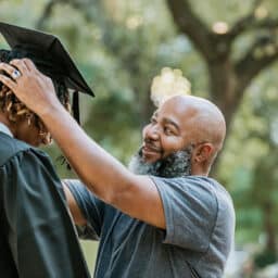 Proud father adjusts his kid's graduation cap before the graduation ceremony.